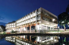 The Biosciences Research Centre in Melbourne at dusk, reflected in the water beside it